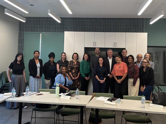 Rep. Peters stands with participants of a homelessness roundtable discussion