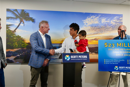 Rep. Peters shakes hand with a constituent during the press conference
