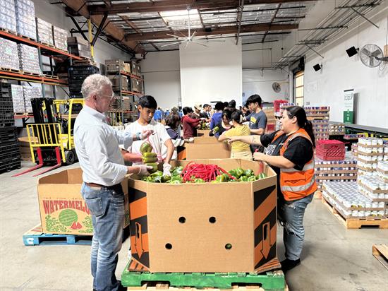 Rep. Peters bags produce while volunteering at the San Diego Food Bank